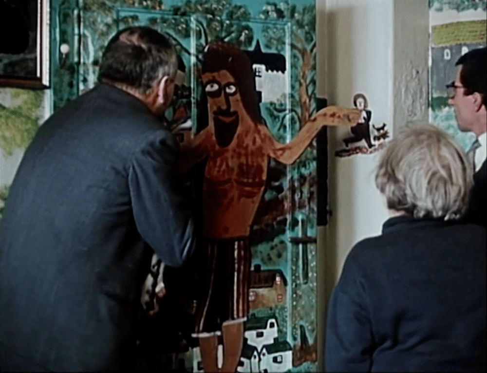 A trio of people inspect an unusual Jesus mural in Pearls of the Deep