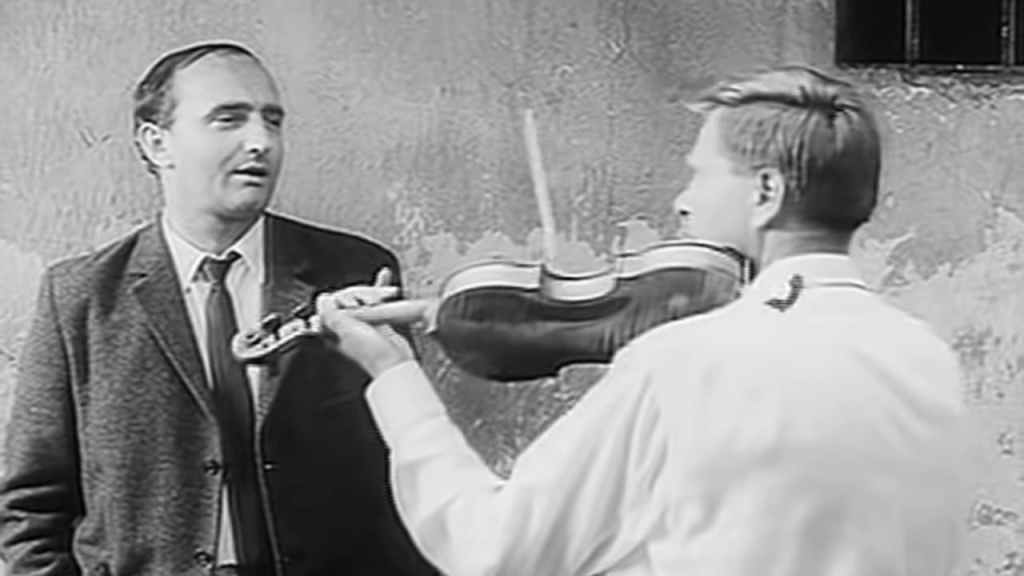 Ludvik speaking to an old friend playing the violin in The Joke