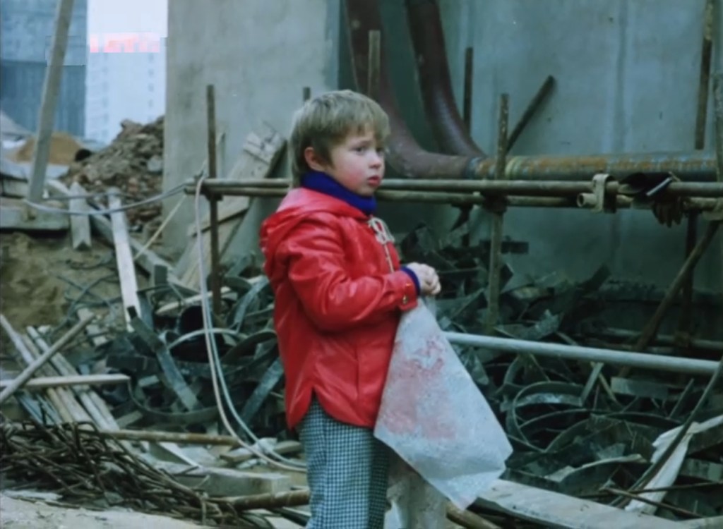 A young boy amid the rubble in Prefab Story