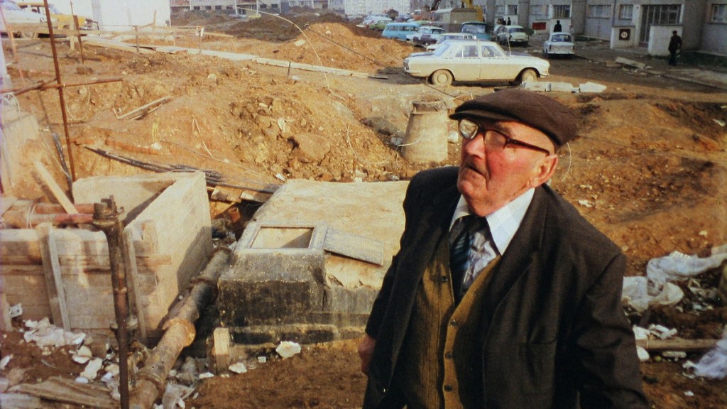 An old man wanders through the construction site in Prefab Story